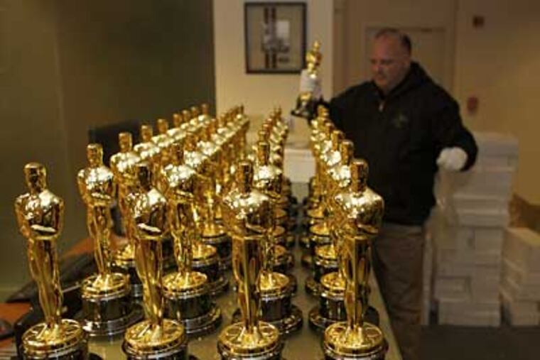 Steve Meissner, 47, an assistant to the Academy president, and the official Oscar keeper, unpacks the Oscars. (AP Photo/Damian Dovarganes)
