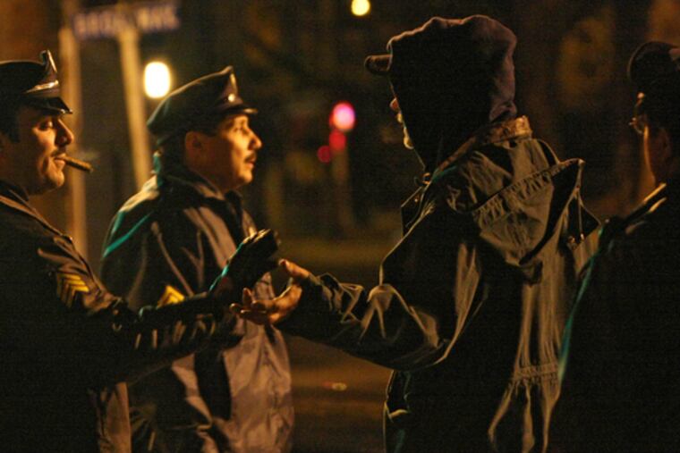 Sgt. John Morris (left) and Oficer Julio Malave of the Camden police talk with men on the corner of Broadway and Viola.