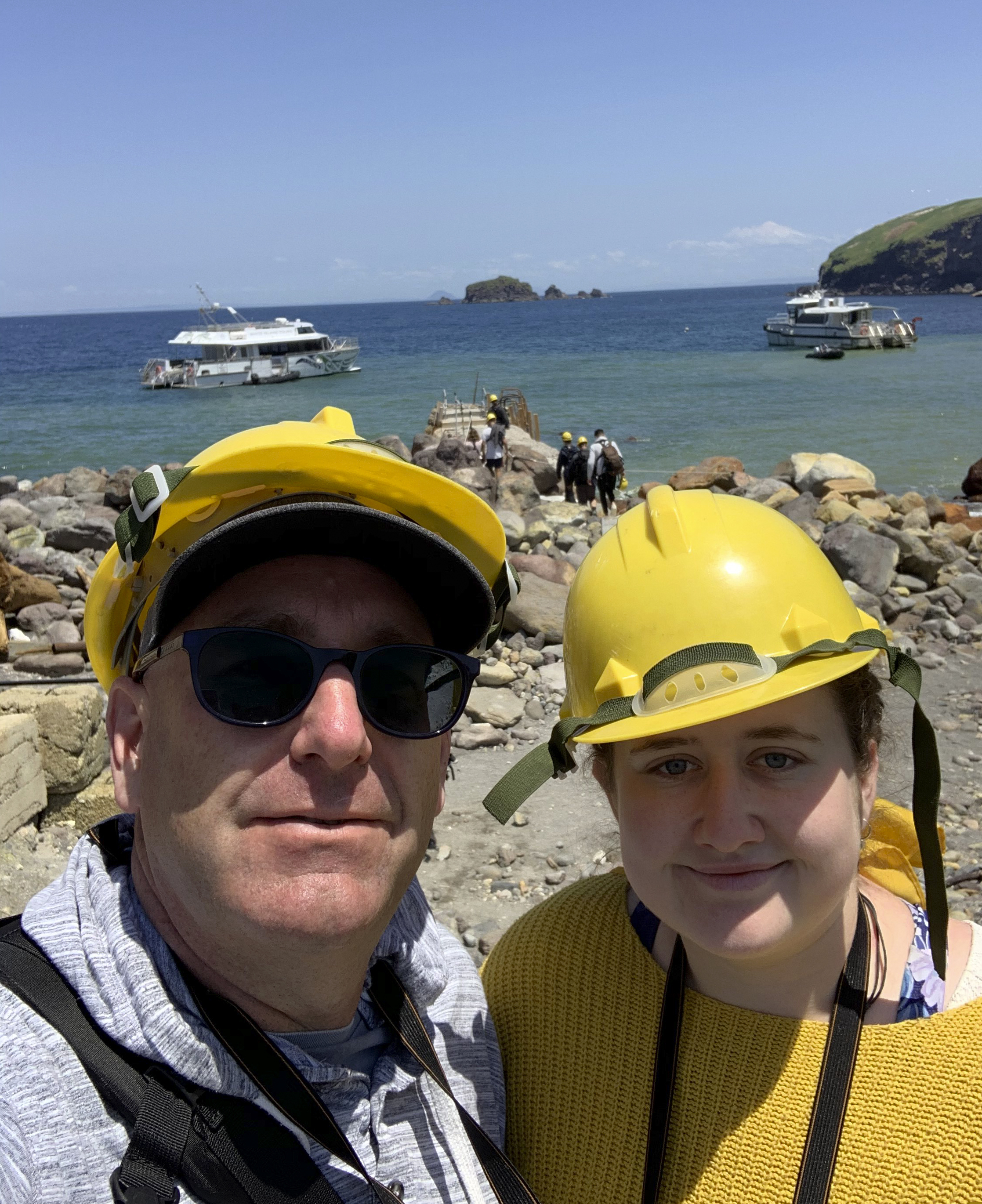 In this Monday, Dec. 9, 2019, photo provided by Lillani Hopkins, Lillani Hopkins pictured with her father Geoff prior to the eruption on White Island off the coast of Whakatane, New Zealand. Lillani Hopkins was feeling seasick and keeping her eyes trained on the open water as her tour boat swung around for a last view of the White Island volcano on Monday afternoon, Dec 9, 2019. Suddenly people started gasping and then her dad whacked her, telling her to turn around. The eruption had been so silent she hadn't heard it over the noise of the boat's engines. (Lillani Hopkins via AP)