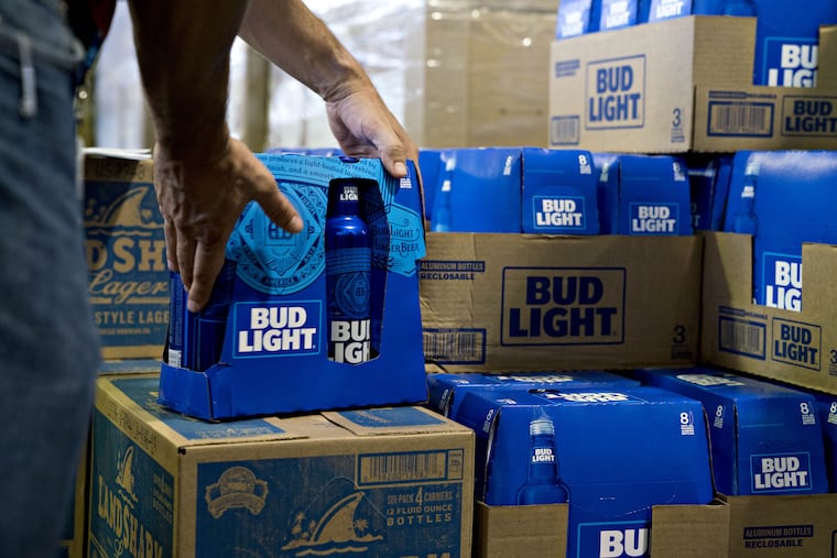 An employee adjusts bottles of Bud Light brand beer at an Anheuser-Busch InBev NV facility in Williamsburg, Va.