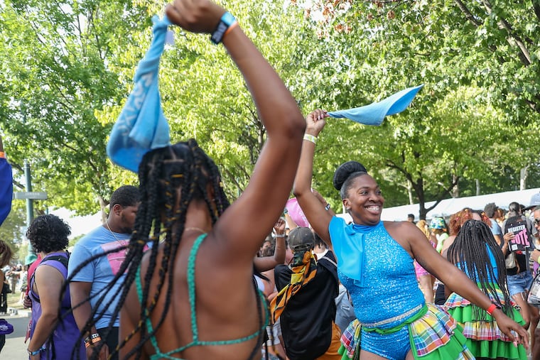 People dance in front of a booth advertising tourism to the Virgin Islands at the Made in America festival in Philadelphia on Saturday.