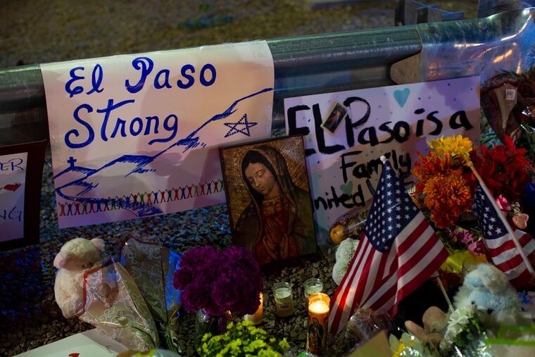 A Virgin Mary painting, flags and flowers adorn a makeshift memorial for the victims of Saturday's mass shooting at a shopping complex in El Paso, Texas, Sunday, Aug. 4, 2019. (AP Photo/Andres Leighton)