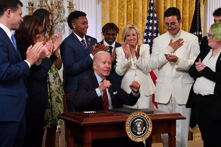U.S. President Joe Biden, center, reacts after signing an Executive Order Advancing Equality for LGBTQI+ Individuals during a reception celebrating Pride Month in the East Room of the White House, Wednesday, June 15, 2022. (Nicholas Kamm/AFP/Getty Images/TNS)