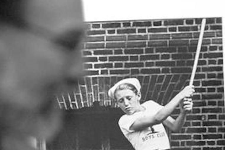 Rob Crites, director of photography at the Art Institute, views a photo shot about 1950 of a boy playing stickball. The exhibition includes 52 photos from the late 19th century through the present.