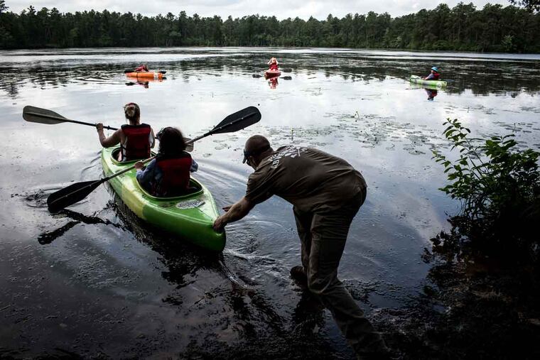 Rob Laucks pushes Joyce Rivera (center) and her niece Jackie May out into Atsion Lake in Shamong, N.J.