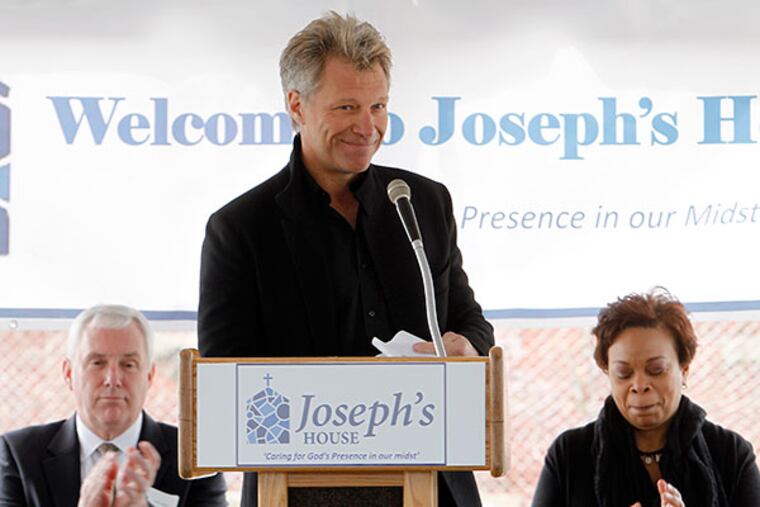Jon Bon Jovi finishes his remarks at the opening ceremony for Camden's new homeless shelter, Joseph’s House, on April 1, 2014. Left is Executive Dir. of Joseph’s House, John Klein. Camden Mayor Dana Redd sits to his right. ( AKIRA SUWA / Staff Photographer )