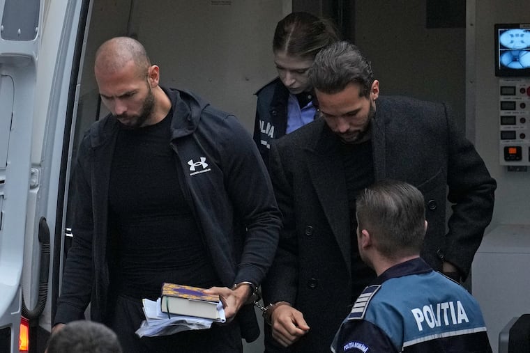 Andrew Tate, right, and his brother Tristan, left, are brought by police officers to the Court of Appeal, in Bucharest, Romania, Tuesday, Jan. 10, 2023.