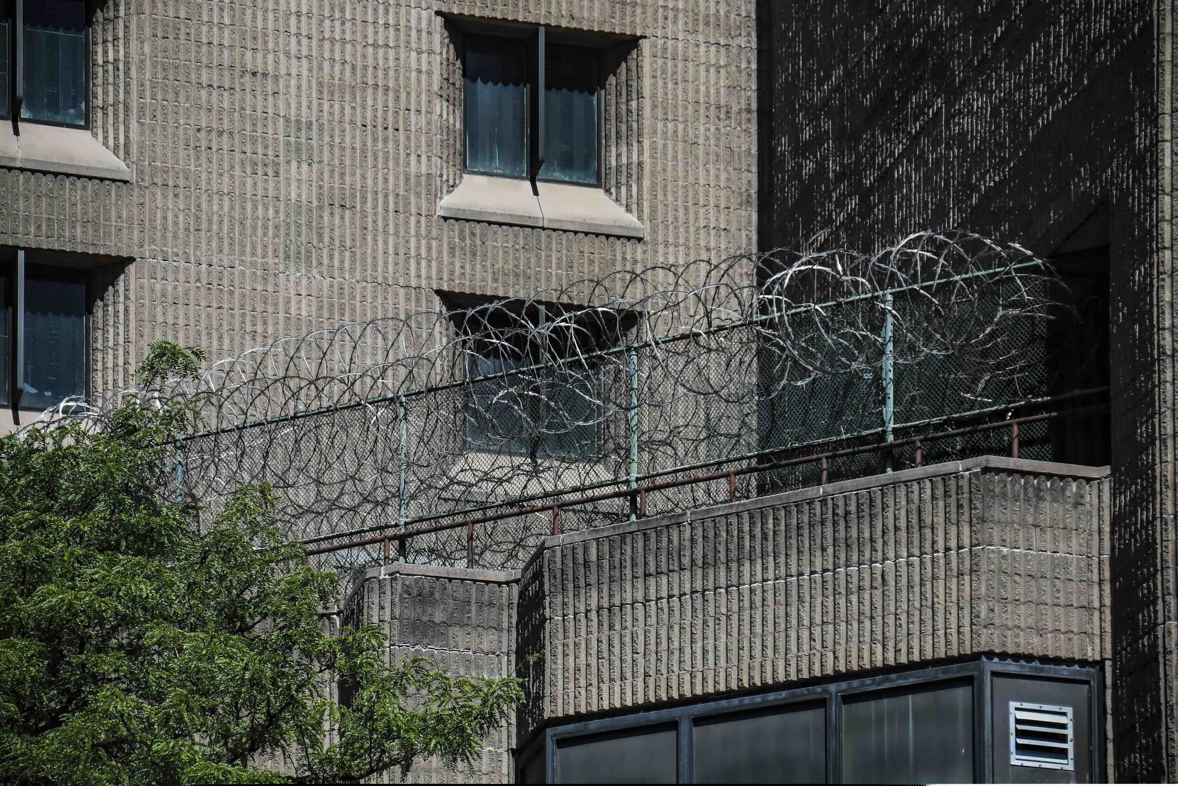 FILE - This Aug. 10, 2019, shows razor wire fencing at the Metropolitan Correctional Center in New York. Inmates and advocates said numerous inmates exhibiting flu-like symptoms were not tested or quarantined at several facilities, including at FCI Yazoo City in Mississippi and at the Metropolitan Correctional Center in New York. (AP Photo/Bebeto Matthews, File)