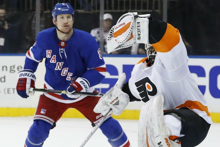 New York Rangers left wing Cody McLeod (8) watches as Philadelphia Flyers goaltender Alex Lyon (49) makes a glove save in the second period of an NHL hockey game in New York, Sunday, Feb. 18, 2018.