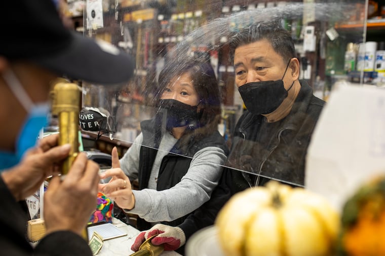 Justin Lee, 65, owner of Fern Rock Hardware, and wife Son Lee, 60, help a customer at their shop in Philadelphia. Lee applied for only one of the two rounds of PPP funding, receiving about $5,000 in assistance.