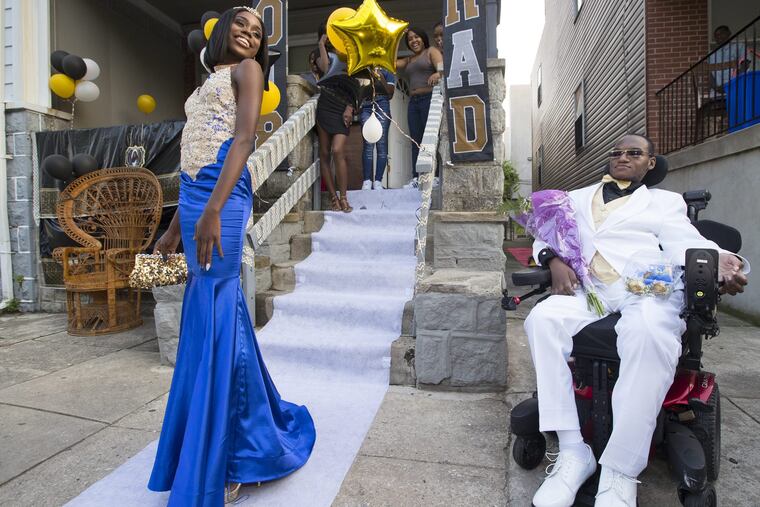Lariq Byrd, right, was shot and paralyzed the day after Christmas in 2015. He is going to the Gratz High School senior prom with Daamiera Carr and with the help of Magee Rehab, which hooked him up with a wheelchair accessible van. Lariq gets his first glimpse of his date at her home on June 1, 2018. CHARLES FOX / Staff Photographer