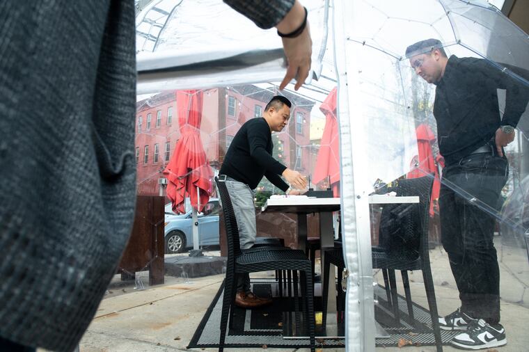 Tim Lu (left) and Derek Gibbons working in 2022 in an outdoor dining enclosure at Figo, which closed in March 2025.