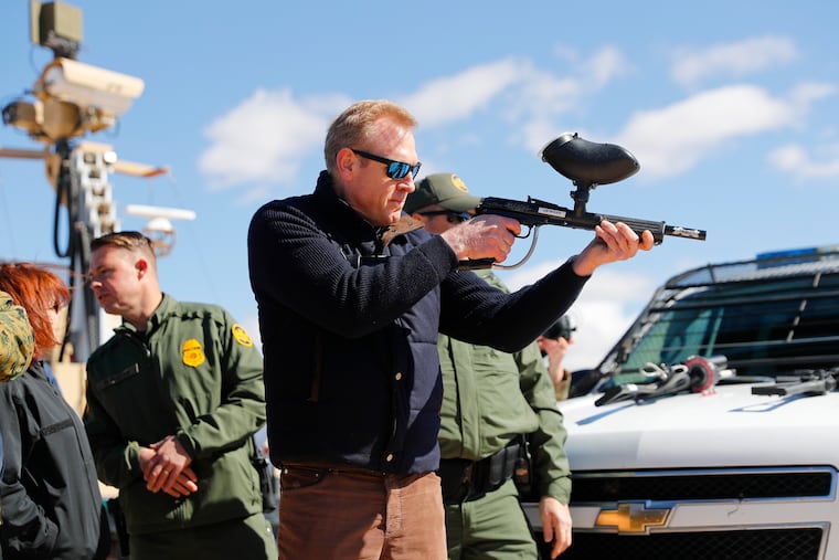 Acting Secretary of Defense Patrick Shanahan, center, fires a modified painted ball gun during a tour of the US-Mexico border at Santa Teresa Station in Sunland Park, N.M., Saturday, Feb. 23, 2019. Top defense officials toured sections of the U.S.-Mexico border Saturday to see how the military could reinforce efforts to block drug smuggling and other illegal activity, as the Pentagon weighs diverting billions of dollars for President Donald Trump's border wall. (AP Photo/Pablo Martinez Monsivais)