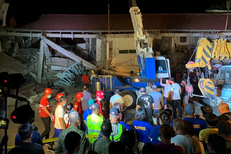 Workers continue rescue efforts on people still trapped inside a collapsed building at Porac town, Pampanga province, northern Philippines Monday, April 22, 2019. A strong 6.1 magnitude earthquake in the north Philippines on Monday trapped some people in a collapsed building, damaged an airport terminal and knocked out power in at least one province, officials said. (AP Photo/Bullit Marquez)