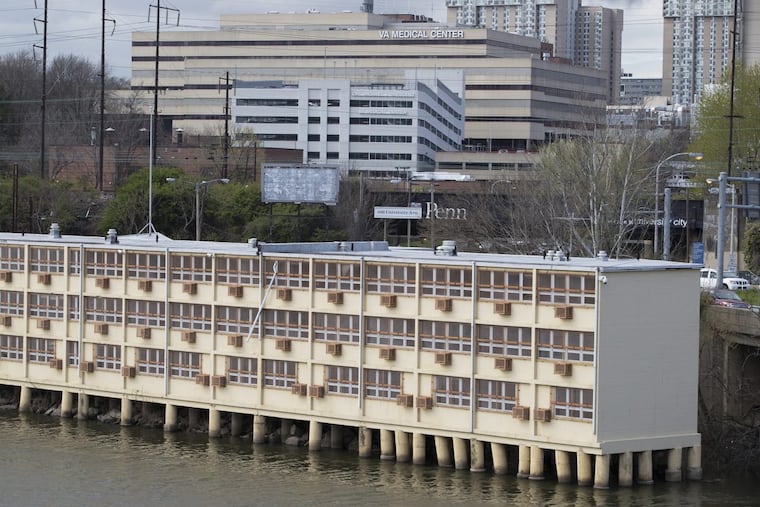 A former motel and prison halfway house, which sits on wooden posts on the West Philly edge of the Schuylkill near an I-76 on-ramp, could become the University of Pennsylvania’s missing link, connecting its campuses in West Philly with its Pennovation business incubator on Grays Ferry Avenue in South Philadelphia. A proposed rezoning of the 600 South University Ave. site from medium-industrial to CMX-5 would let the owner or tenant build something creative — even something large — on the triangle of land and the low-water Schuylkill riverbed that is part of the property. It is shown on April 19, 2018 from the 34th St. Bridge. CHARLES FOX / Staff Photographer