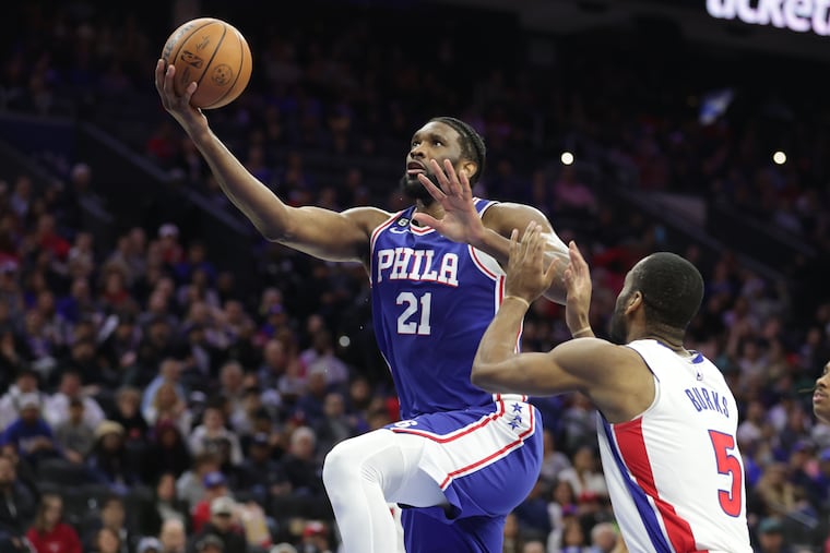 Joel Embiid (left) of the Sixers goes up for a basket against Alec Burks of the Pistons during the second half of their game at the Wells Fargo Center on Tuesday. The Sixers won, 147-116.