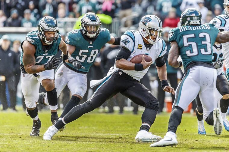 Cam Newton (center) tries to evade the Eagles' Michael Bennett (left), Jordan Hicks (left center) and Nigel Bradham in the fourth quarter.