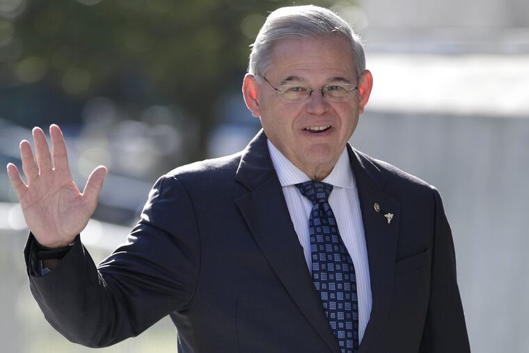 Sen. Bob Menendez waves to reporters while arriving at the Martin Luther King, Jr. Federal Courthouse.