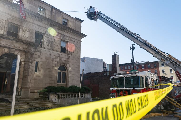 Members of the Philadelphia Fire Department work at the scene of a fire at the Art Alliance building that began early Friday.