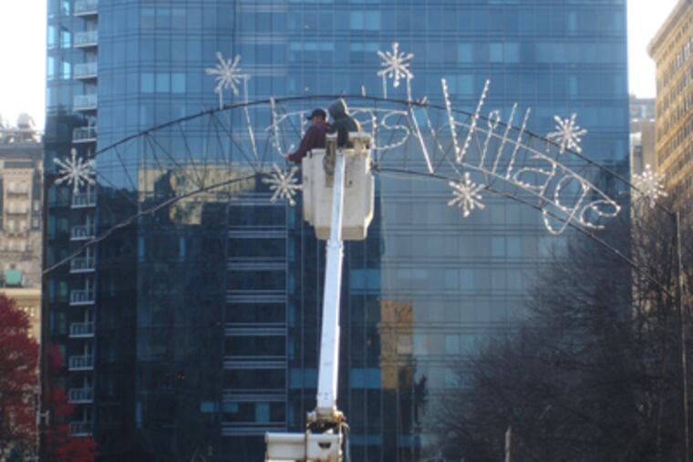 Crews remove the word 'Christmas' from the sign at Dilworth Plaza. (Vance Lehmkuhl / Staff)