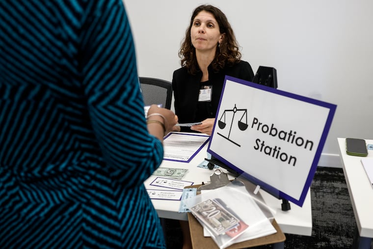 Maya Sosnov, a law clerk for Judge Theodore McKee, works the probation station at a reentry simulation event hosted by the Philadelphia Bar Foundation. Participants were given a wallet with a new identity in it, replicating the challenges a person coming home after being incarcerated might face.
