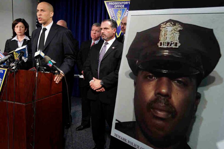 Officer William Johnson's photo is shown at a news conference about his killing. Among those answering questions were (from left) Carolyn Murray, acting Essex County prosecutor; Mayor Cory Booker; and Samuel DeMaio, acting police director.