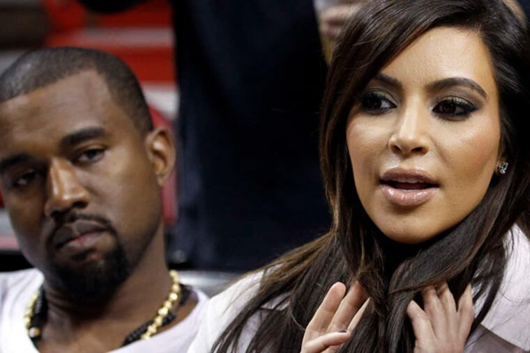 Kanye West and Kim Kardashian at an NBA game. "Any woman . . . you're in love with or that loves you is going to command a certain amount of . . . energy," he says. (AP file photo)