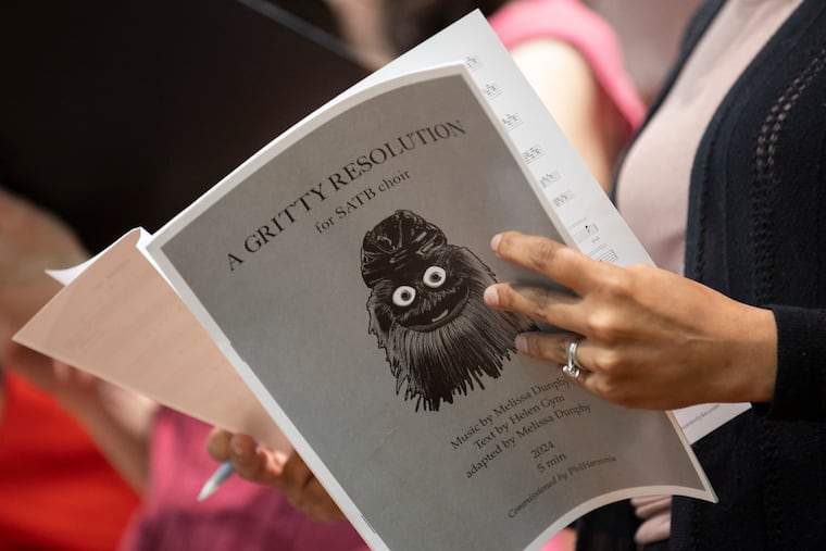 A member of PhilHarmonia holds sheet music for "A Gritty Resolution," an a cappella choral piece by Philly composer Melissa Dunphy that was commissioned by the choir for its 10th anniversary concert.