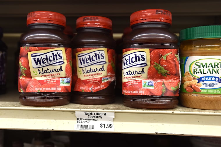 Banged-up plastic jars of Welch's strawberry spread sit on a shelf at Green Hills Farm Discount Grocer, a so-called dent-and-bent store in Lititz, Lancaster County. Normally more than $4, each jar goes for $1.99.