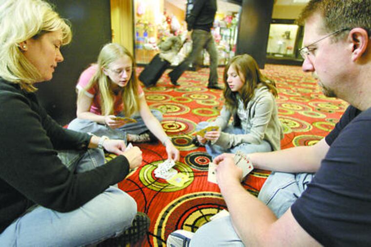 Tom and Kristina Waltz play cards with daughters Jessica (left) and Samantha at the O'Hare Hilton in Chicago, where flight delays and cancellations had trapped them since Tuesday.