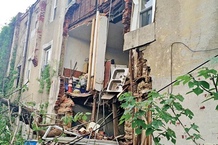 A family of five was displaced Sunday, May 11, 2014, when the back wall of a rowhouse on Glenmore Avenue collapsed. City inspectors responding to the collapse deemed 16 other buildings on the same street as unsafe or dangerous.