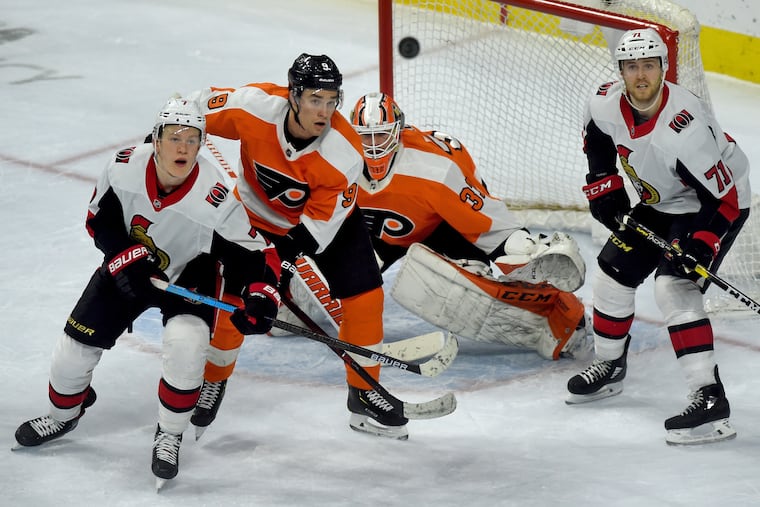 From left, Ottawa's Brady Tkachuk, the Flyers' Ivan Provorov, goaltender Brian Elliott and Ottawa's Chris Tierney eye an airborne puck during the third period.