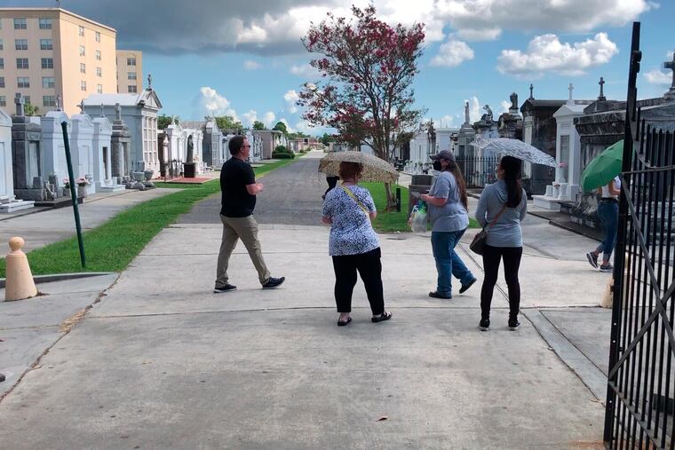 Tourists wander through a historic New Orleans cemetery on Thursday, Aug. 12, 2021. The city’s vital tourism industry was devastated by the COVID-19 epidemic in 2020. It had begun making a comeback in recent months as vaccines have become available. But the spread of the highly contagious delta variant of the coronavirus and a low vaccination rate in Louisiana are being blamed for a resurgence of COVID-19 that has stressed hospitals and led to cancellations, for the second year, of tourist-drawing events. (AP Photo/Kevin McGill)