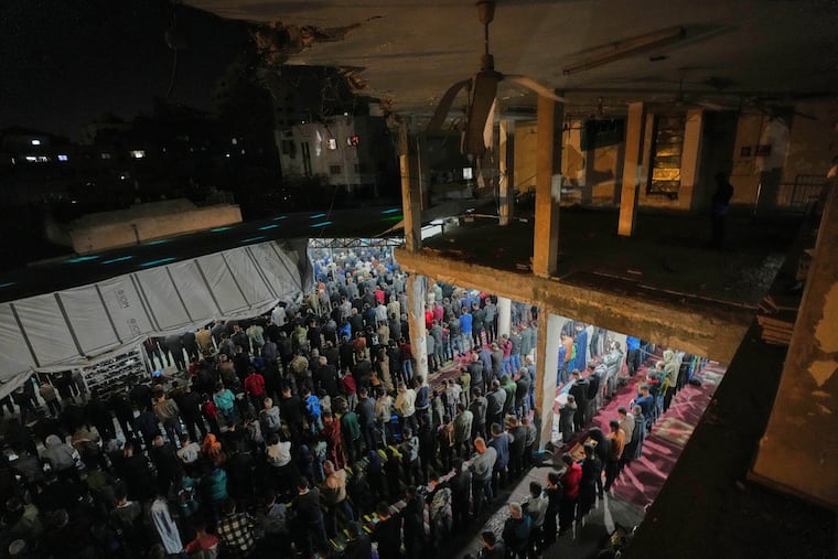 Muslim worshipers perform evening Tarawih prayer on the first night of the holy fasting month of Ramadan at the Alkanz Mosque, which was damaged during the Israel–Hamas war, in Gaza City.