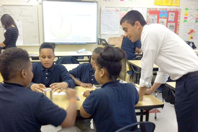 JCamden06. This shows Superintendent Paymon Rouhanifard observing a group of 7th-grade students as they work together to build a card tower.