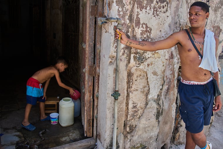 A youth collects water from the bottom floor of a residential building, during a blackout that stopped the water pump, in Havana, Cuba, Tuesday, July 14, 2026. The current U.S. oil embargo on the island has led to multiple blackouts of its power grid.