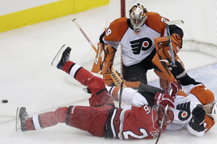 Carolina Hurricanes' Erik Cole (26) collides with Kimmo Timonen in front of goalie Ray Emery during the second period of the Flyers' 2-0 win yesterday. (AP Photo/Gerry Broome)