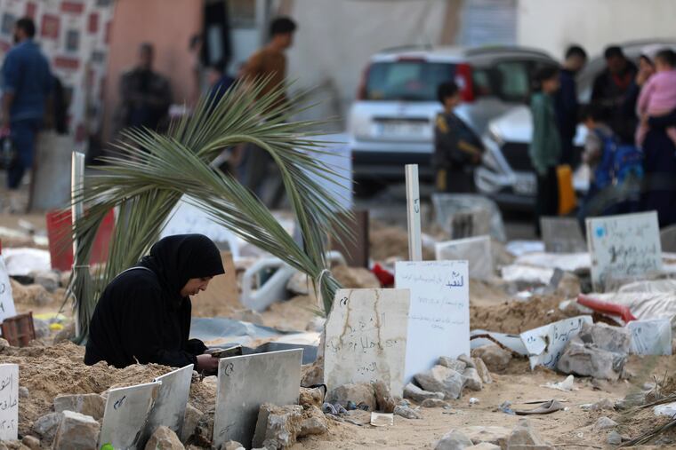 Palestinians on Sunday visit the graves of people killed in the Israeli bombardment of the Gaza Strip and buried inside the Shifa Hospital grounds in Gaza City.