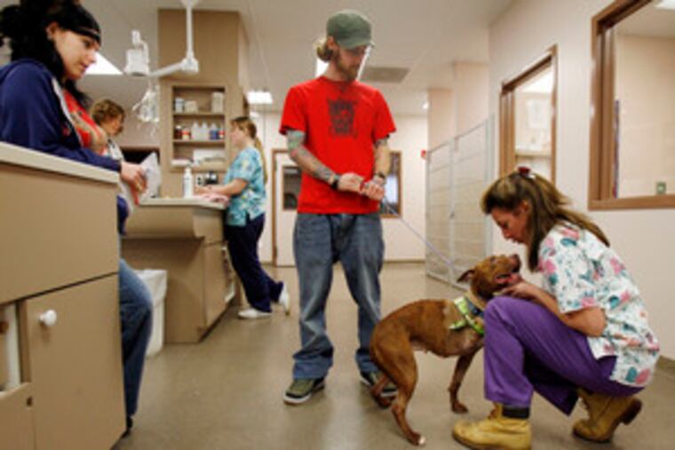 Rosie gets a goodbye from Lisa Passaro of the Rothman Animal Hospital staff before heading to Philadelphia with her new owners, Kathryn Smith and Michael Armine of the city's Fairmount section.