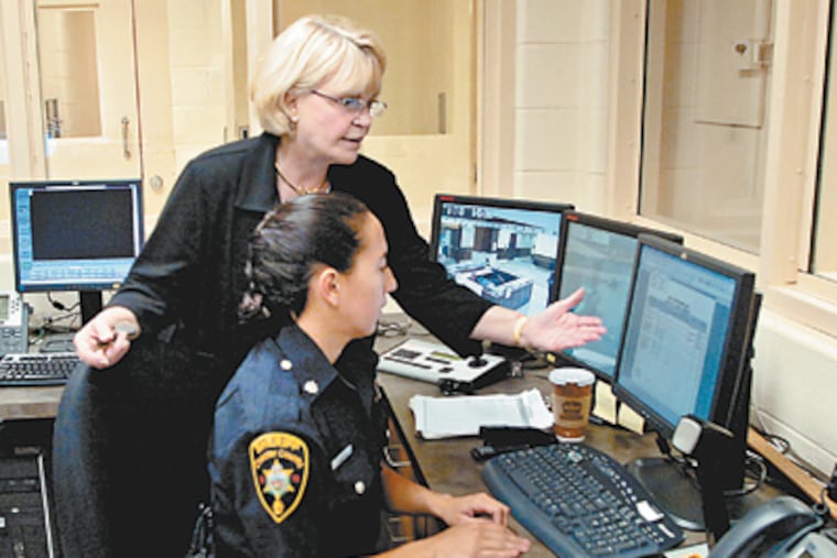 Chester County Sheriff Carolyn “Bunny” Welsh and one of her “extraordinary deputies,” Suzanne Campos, in the control room in the Chester County Justice Center. (Clem Murray / Staff Photographer)