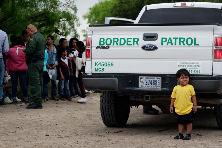 In this Thursday, March 14, 2019, photo, William Josue Gonzales Garcia, 2, who was traveling with his parents, waits with other families who crossed the nearby U.S.-Mexico border near McAllen, Texas. They are waiting for Border Patrol agents to check names and documents. Immigration authorities say they expect the ongoing surge of Central American families crossing the border to multiply in the coming months. (AP Photo/Eric Gay)