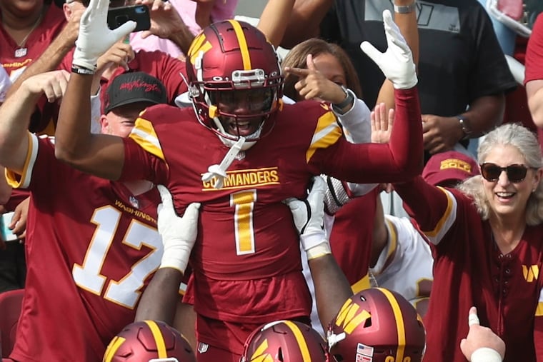 Washington Commanders wide receiver Jahan Dotson hops into the FedEx Field stands to celebrate a touchdown against the Eagles on Oct. 29, 2023.