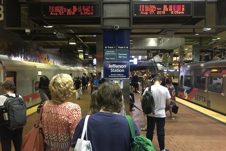 Commuters at Jefferson Station check displays Wednesday evening for updates on train delays and service suspensions.