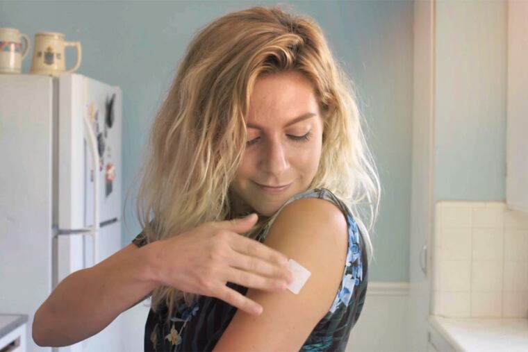 A woman demonstrates how to use a PatchMD product,