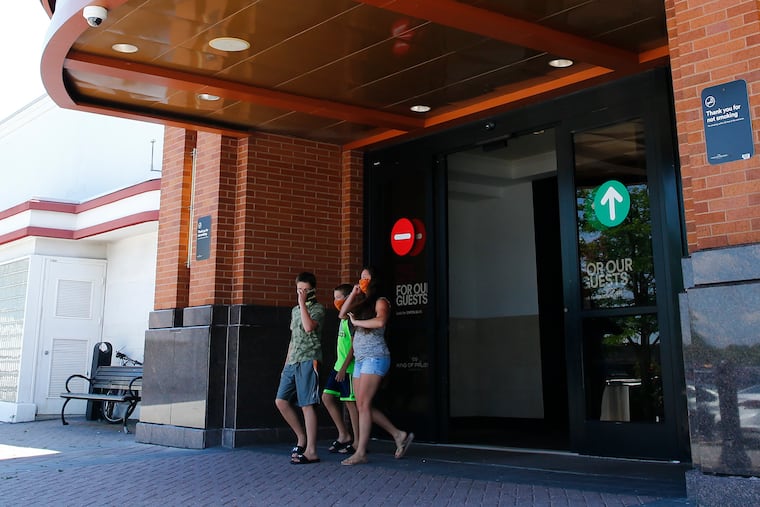 Shoppers wearing face masks leave the King of Prussia Mall on the day it reopened, June 26.