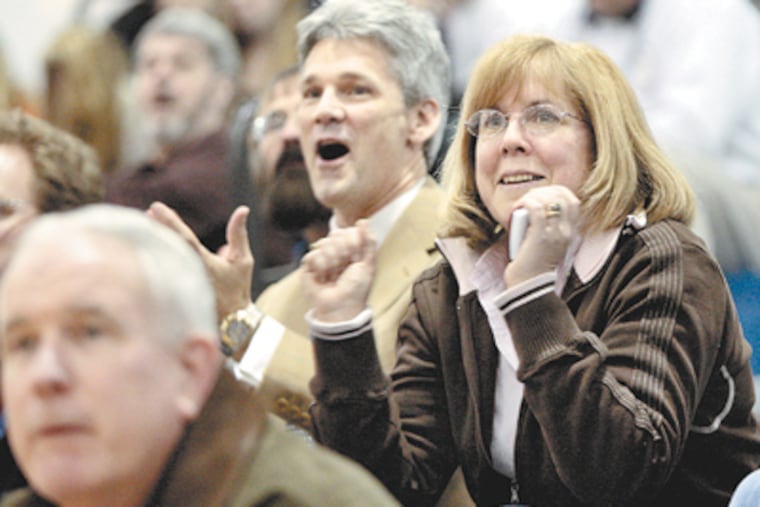Mike and Rita Pearson of West Chester cheer on their daughter, Rachel, at an Archbishop Carroll game. The Pearsons are among the many local families whose lives revolve around basketball. (Elizabeth Robertson / Staff Photographer)