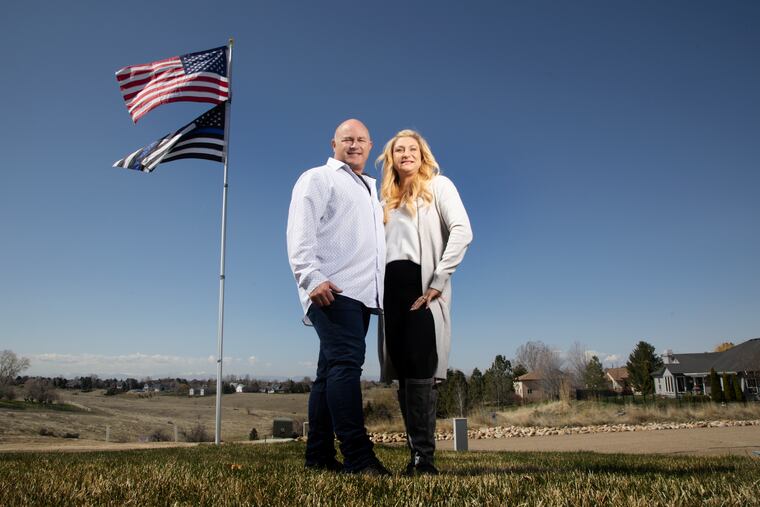 Jennifer and Tim Kohl pose for a photo in their front yard with the American flag and a thin blue line flag in Star, Idaho.