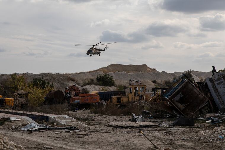 A Ukrainian military helicopter flies over destroyed industrial vehicles in the Kherson region on Sunday.