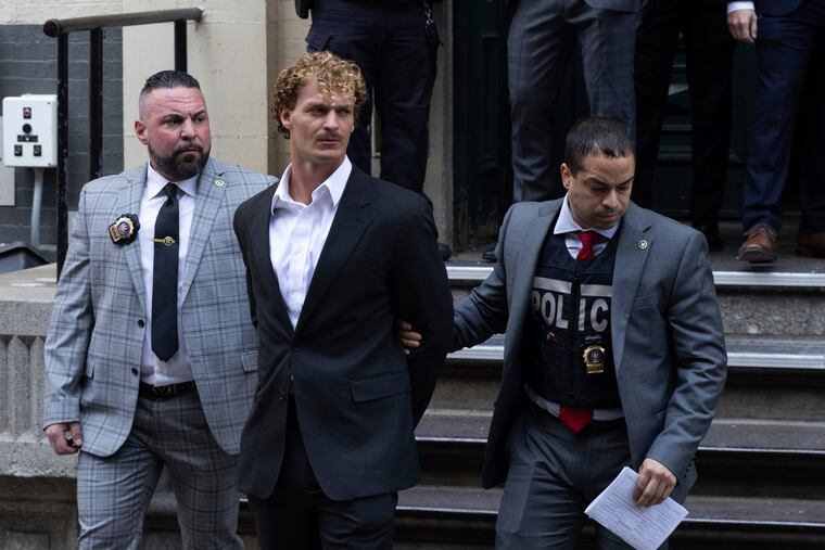Daniel Penny, center, is walked by New York Police Department detectives detectives out of the 5th Precinct. Manhattan prosecutors announced Thursday they would bring the criminal charge against Penny, 24, a U.S. Marine Corps veteran, in the May 1 death of 30-year-old Jordan Neely.