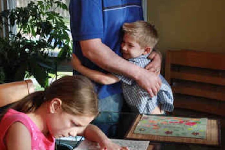 Tad Marks with son Jesse Marks, daughter Susana Nickerson, at their Plymouth, Mass., home. Marks and his wife pay $78 a month for required state-subsidized health insurance.